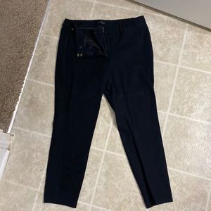 Slacks, black, with some creases from folding and a bit of wear on the hems.
